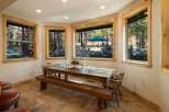 Enjoy breathtaking forest views from this charming dining area, featuring a rustic wooden table and bench perfect for intimate gatherings.