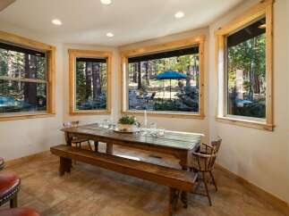 Enjoy breathtaking forest views from this charming dining area, featuring a rustic wooden table and bench perfect for intimate gatherings.
