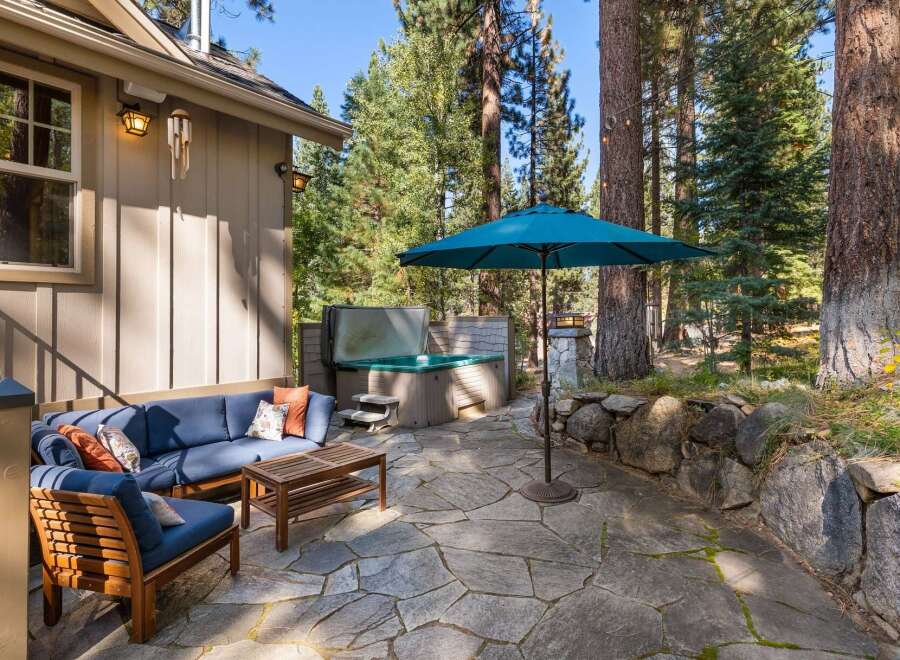 Enjoy outdoor living at its finest with this inviting patio space, featuring a luxurious hot tub perfect for relaxation and a comfortable seating area for gatherings.