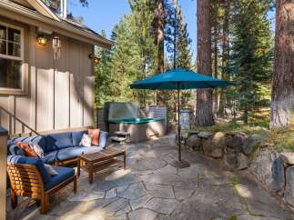 Enjoy outdoor living at its finest with this inviting patio space, featuring a luxurious hot tub perfect for relaxation and a comfortable seating area for gatherings.