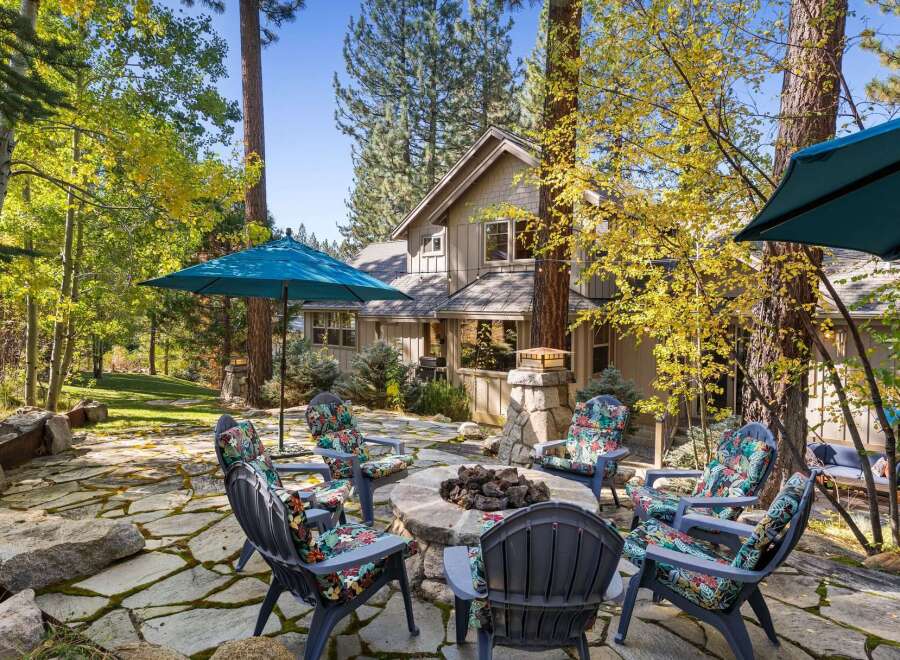 Enjoy the crisp autumn air and vibrant foliage surrounding this charming home's outdoor living space.