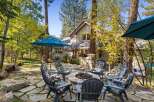 Enjoy the crisp autumn air and vibrant foliage surrounding this charming home's outdoor living space.