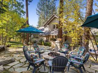 Enjoy the crisp autumn air and vibrant foliage surrounding this charming home's outdoor living space.