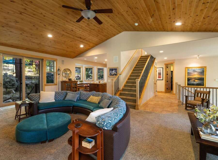 Experience the warmth of this inviting living space, featuring a stunning curved sectional sofa and a large ottoman perfect for relaxation.
