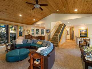 Experience the warmth of this inviting living space, featuring a stunning curved sectional sofa and a large ottoman perfect for relaxation.