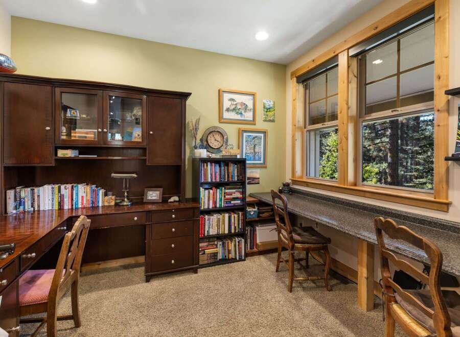 This home office features a spacious wooden desk with a hutch, providing ample storage and display space.