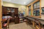 This home office features a spacious wooden desk with a hutch, providing ample storage and display space.