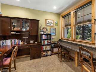 This home office features a spacious wooden desk with a hutch, providing ample storage and display space.