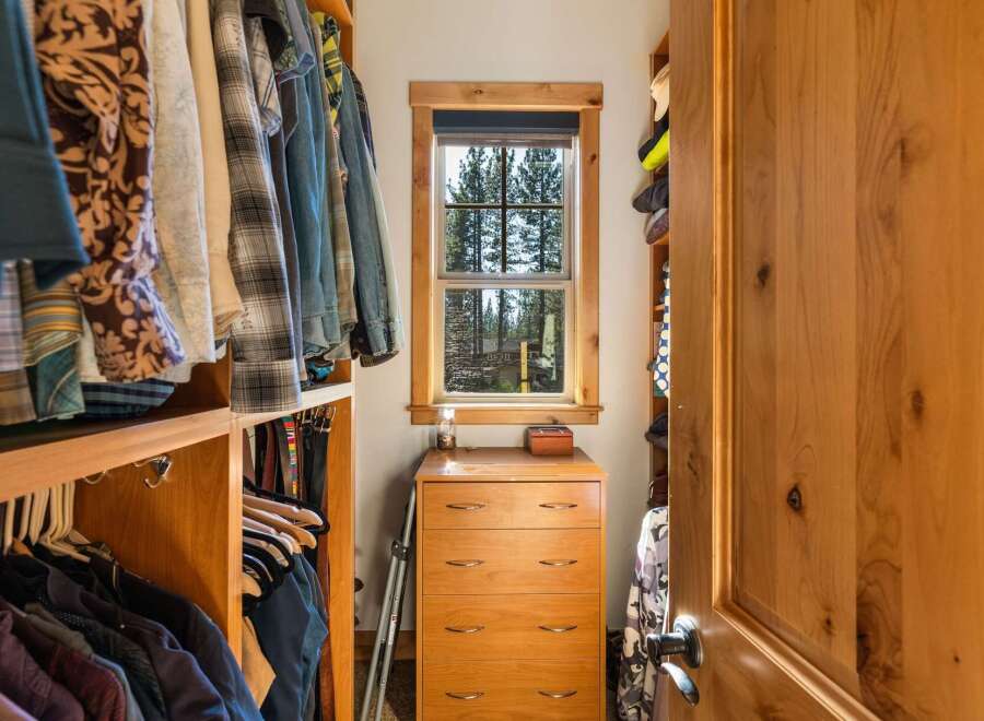 This spacious walk-in closet features custom wood shelving and ample hanging space for a well-organized wardrobe.
