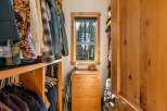 This spacious walk-in closet features custom wood shelving and ample hanging space for a well-organized wardrobe.