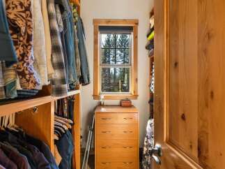 This spacious walk-in closet features custom wood shelving and ample hanging space for a well-organized wardrobe.