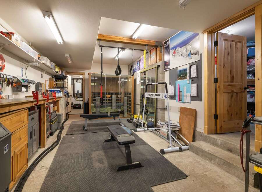 This versatile space offers a dedicated home gym area complete with a weight bench, resistance bands, and a ski training machine, perfect for maintaining an active lifestyle.