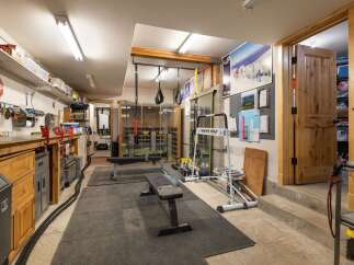 This versatile space offers a dedicated home gym area complete with a weight bench, resistance bands, and a ski training machine, perfect for maintaining an active lifestyle.