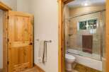 Step into this charming bathroom featuring a natural wood door and a sleek glass-enclosed shower.