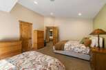 This spacious bedroom features two comfortable beds, each adorned with charming floral bedding and warm brown quilts.