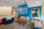 This spacious living area boasts a vibrant blue accent wall adorned with framed artwork, creating a focal point for the room.