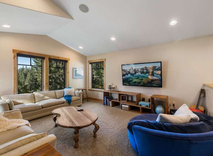 This cozy living room features a large, comfortable sectional sofa and a unique, round wooden coffee table, perfect for gathering.