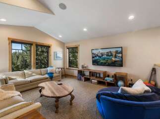 This cozy living room features a large, comfortable sectional sofa and a unique, round wooden coffee table, perfect for gathering.