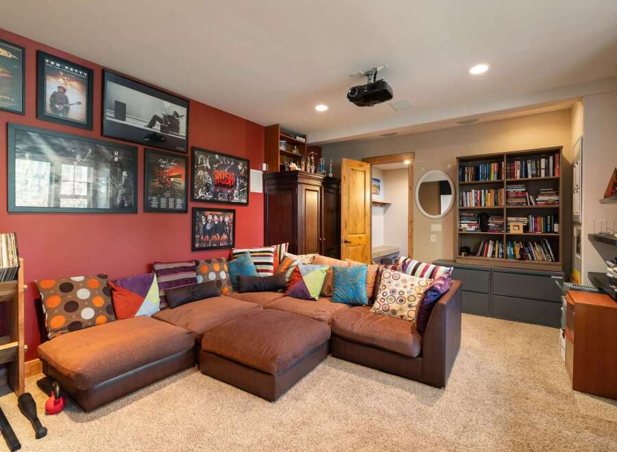 This entertainment room features a large, comfortable sectional sofa adorned with colorful throw pillows, perfect for movie nights or gatherings.
