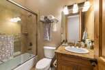 This charming bathroom features a spacious bathtub with a glass enclosure and tiled walls, perfect for a relaxing soak.