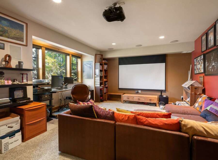Experience ultimate relaxation in this home theater room, complete with a large projector screen and comfortable seating.