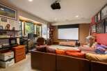 Experience ultimate relaxation in this home theater room, complete with a large projector screen and comfortable seating.