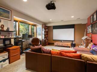 Experience ultimate relaxation in this home theater room, complete with a large projector screen and comfortable seating.