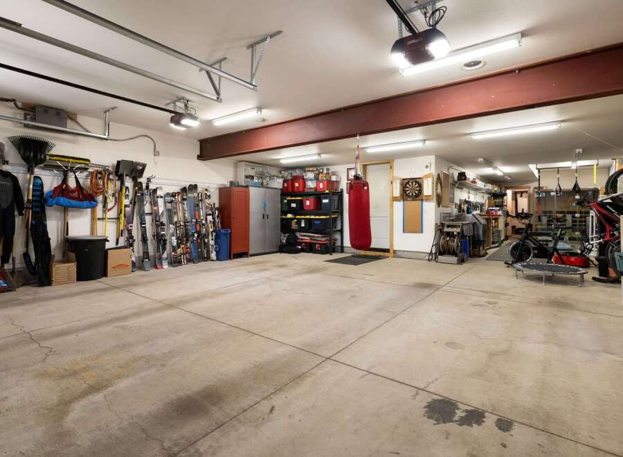 This spacious garage offers ample storage solutions, including tall cabinets and shelving units, perfect for organizing all your gear.