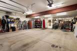 This spacious garage offers ample storage solutions, including tall cabinets and shelving units, perfect for organizing all your gear.