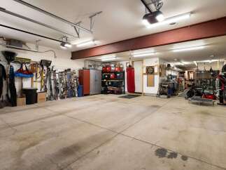 This spacious garage offers ample storage solutions, including tall cabinets and shelving units, perfect for organizing all your gear.