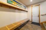 Welcome guests into this charming entryway featuring a long, slatted wooden bench perfect for removing shoes.