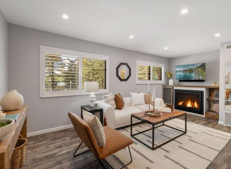 Step into this inviting living room, featuring a cozy fireplace and a large TV for entertainment.