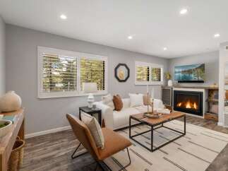 Step into this inviting living room, featuring a cozy fireplace and a large TV for entertainment.
