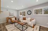 This inviting living room features a plush white sofa adorned with accent pillows and a cozy throw, perfect for relaxation.