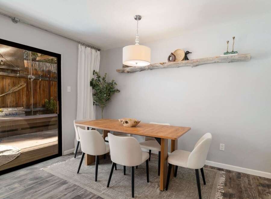 This dining room features a warm wooden table surrounded by elegant cream upholstered chairs, perfect for family gatherings.