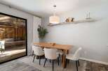 This dining room features a warm wooden table surrounded by elegant cream upholstered chairs, perfect for family gatherings.