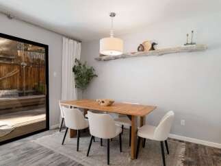 This dining room features a warm wooden table surrounded by elegant cream upholstered chairs, perfect for family gatherings.