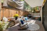 Enjoy outdoor living with this spacious deck featuring a relaxing hot tub and a built-in grill, perfect for entertaining.
