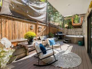 Enjoy outdoor living with this spacious deck featuring a relaxing hot tub and a built-in grill, perfect for entertaining.