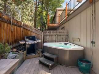 Enjoy outdoor living with this fantastic backyard setup, featuring a spacious hot tub perfect for relaxation and a Weber grill ready for summer barbecues.