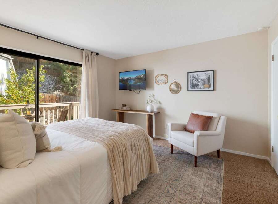 Experience serene living in this charming bedroom, featuring a plush bed adorned with cozy throws and pillows, perfect for relaxation.