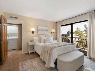 This inviting bedroom features a plush king-sized bed adorned with crisp white linens and a cozy knit throw, perfect for relaxation.