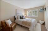 This inviting bedroom features a comfortable queen-size bed adorned with plush pillows and a cozy throw blanket, perfect for relaxation.
