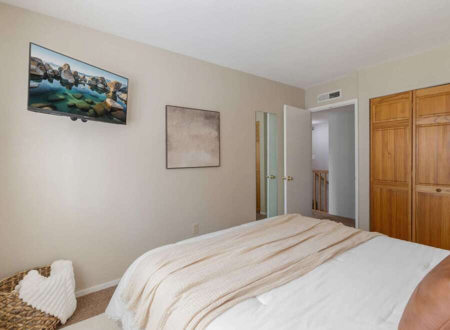 This bedroom offers a modern and comfortable retreat, featuring a wall-mounted television for entertainment and a large closet for ample storage.