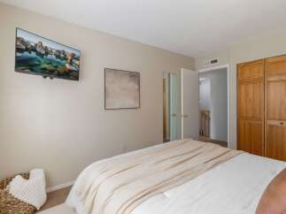 This bedroom offers a modern and comfortable retreat, featuring a wall-mounted television for entertainment and a large closet for ample storage.