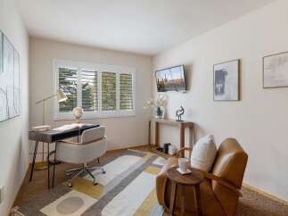 This home office features a modern desk with a globe and a comfortable office chair, perfect for productivity.