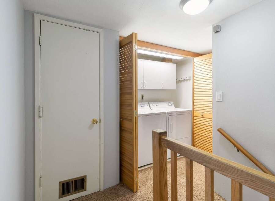 Discover the convenience of a dedicated laundry area, complete with a washer and dryer, neatly tucked away behind louvered doors.