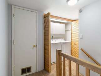 Discover the convenience of a dedicated laundry area, complete with a washer and dryer, neatly tucked away behind louvered doors.