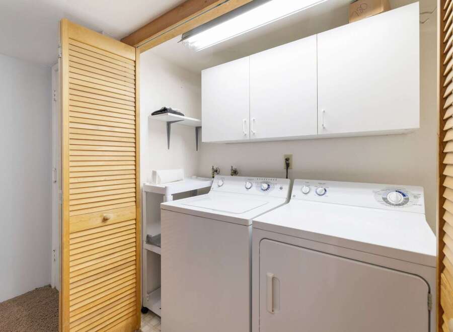 This laundry room features a stacked washer and dryer for efficient use of space.
