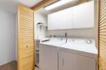 This laundry room features a stacked washer and dryer for efficient use of space.